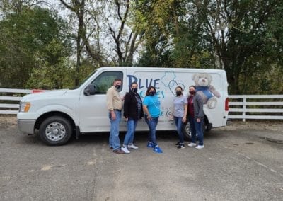 Blue Cares group photo in front of the Blue Cares van